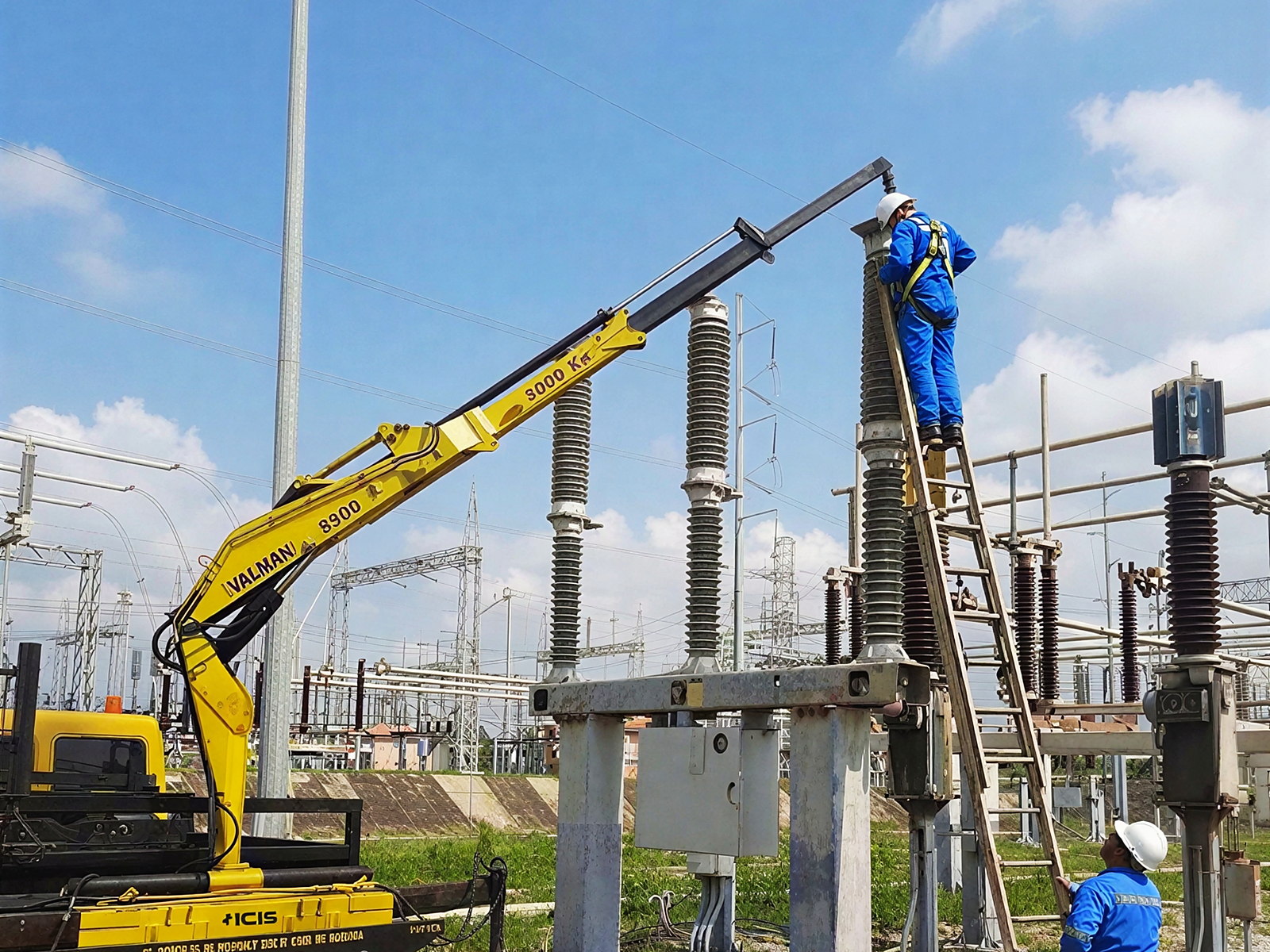 Montaje de un interruptor de potencia de 145 kV en patio de subestación, con grúa sobre camión y personal técnico sobre escalera