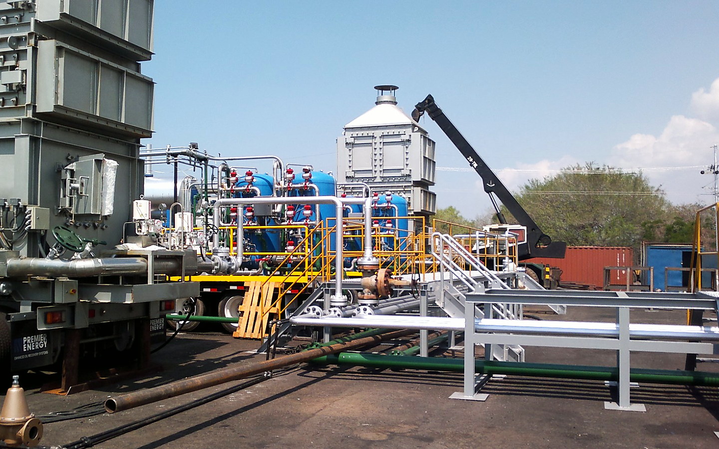 Montaje de calderas sobre plataformas, con tuberías y grúa, en un campo petrolero